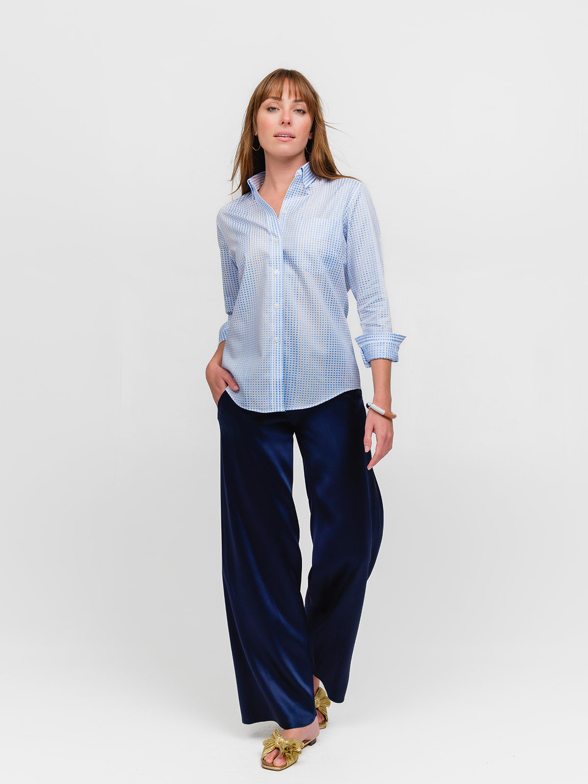 Woman posing while wearing a pale blue polka dot designer button down shirt for women made of fine Italian cotton